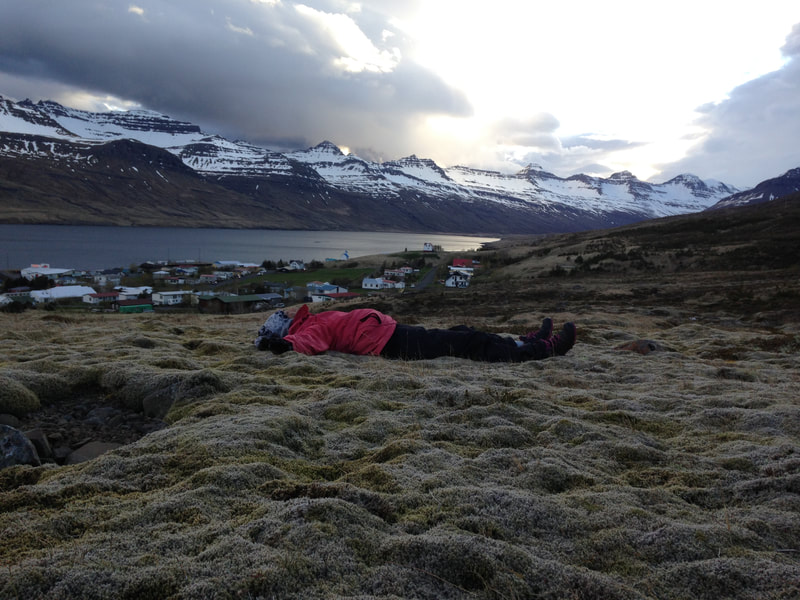 A woman lying in the wild Icelandic nature near Stöðvarfjörður. 